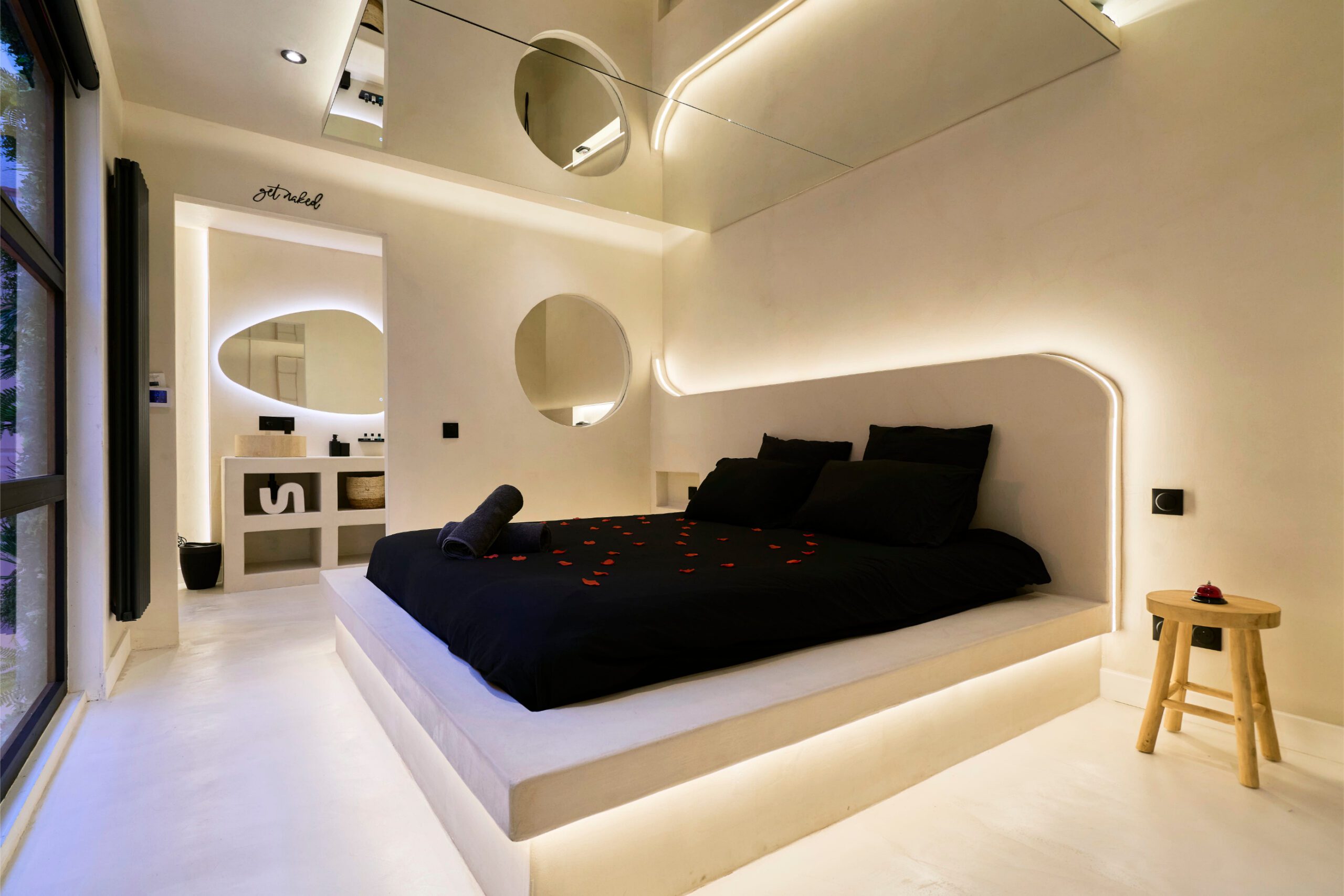 Chambre claire de la Suite Privilège, lit noir et pétales de rose