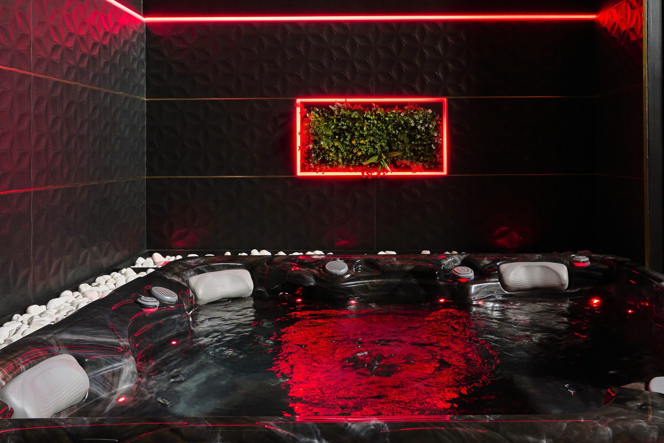 Jacuzzi privatif aux lumières rouges de la Suite Secrète
